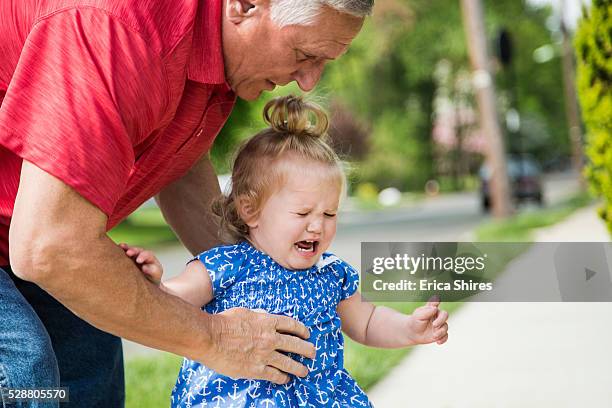 grandfather and granddaughter (12-23 months) standing on street - eenjarig plantenkenmerk stockfoto's en -beelden