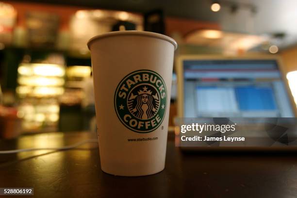 laptop at a starbucks coffee house - starbucks stockfoto's en -beelden