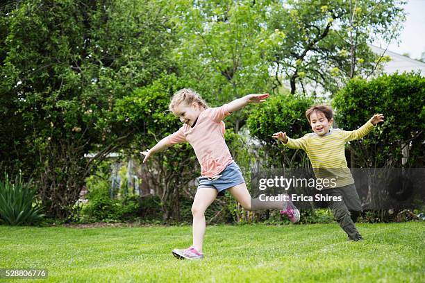 siblings (4-5), (6-7) running in backyard - spielerisch stock-fotos und bilder