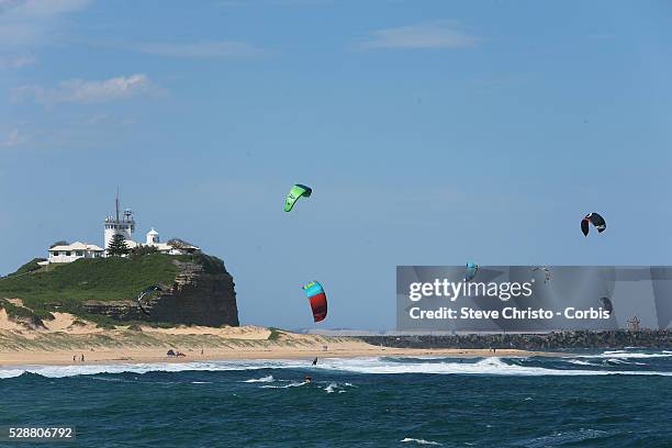 Kite Surfers enjoy the windy conditions at Nobby's beach Newcastle in New South Wales. Kitesurfing or kiteboarding is a surface water sport combining...