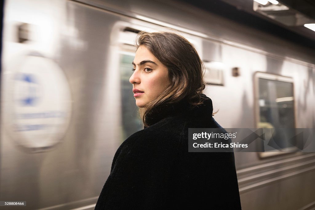 Train arriving at station while woman waits