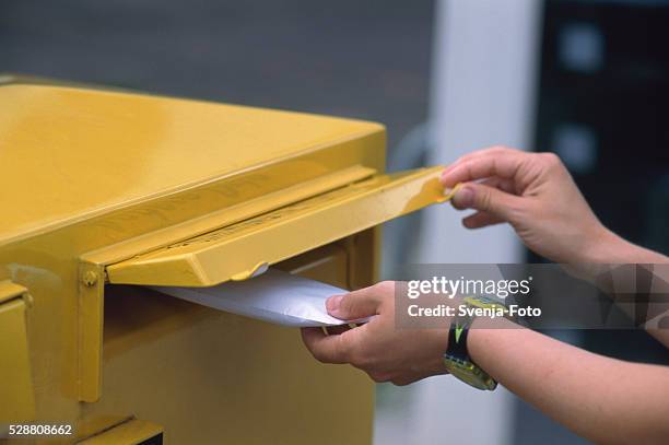 throwing of a letter into a mailbox - mailbox foto e immagini stock