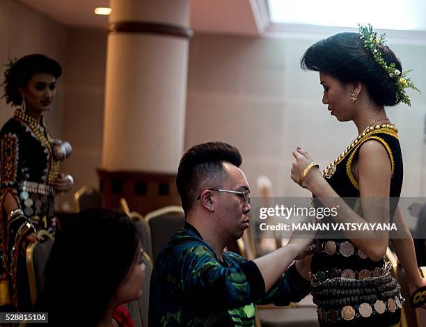Malaysian woman from the indigenous Kadazandusun community of Sabah gets her dress fixed before taking part in the annual "Unduk Ngadau Kaamatan", a...