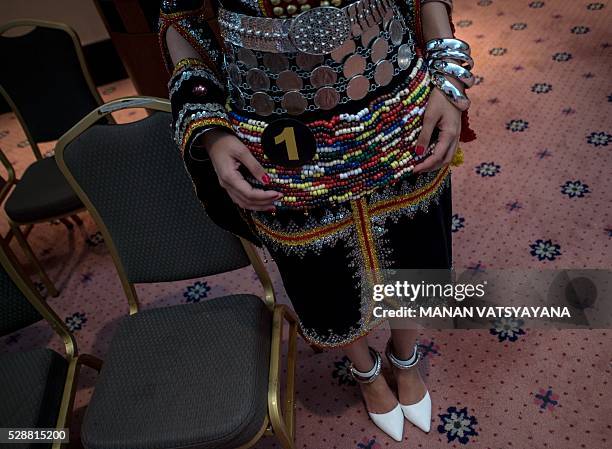 Malaysian woman from the indigenous Kadazandusun community of Sabah wearing a traditional dress waits before taking part in the annual "Unduk Ngadau...