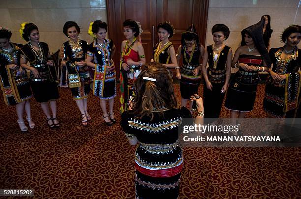 An instructor gives final instructions to Malaysian women from the indigenous Kadazandusun community of Sabah before taking part in the annual "Unduk...