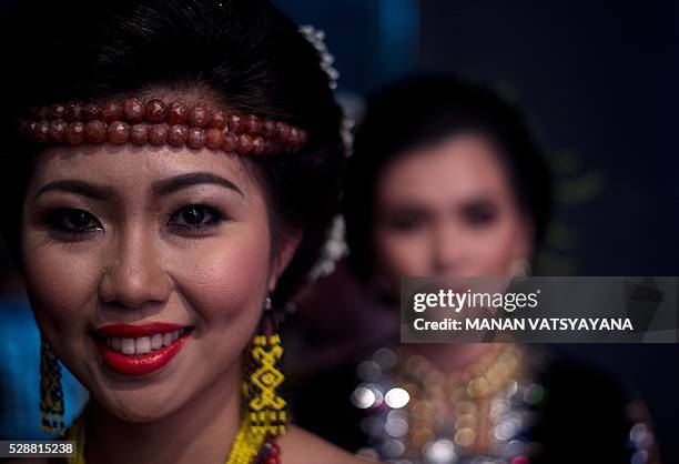 Malaysian woman from the indigenous Kadazandusun community of Sabah wearing traditional head-gear waits backstage during the annual "Unduk Ngadau...