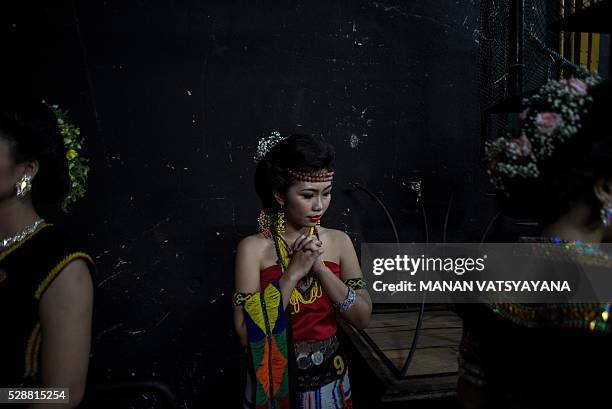 Malaysian woman from the indigenous Kadazandusun community of Sabah prays as she waits backstage during the annual "Unduk Ngadau Kaamatan", a...