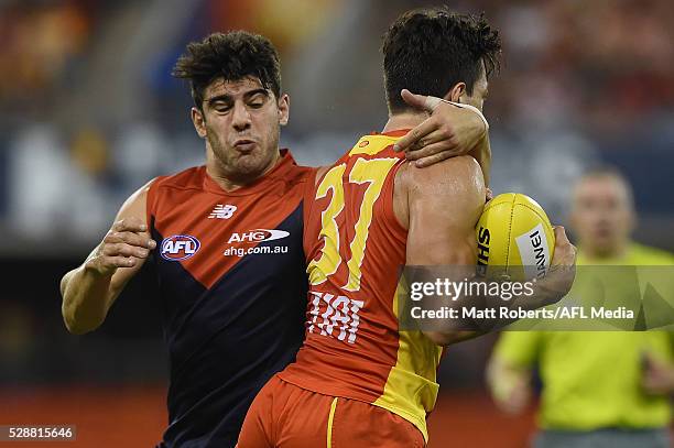 Jesse Lonergan of the Suns is tackled by Christian Petracca of the Demons during the round seven AFL match between the Gold Coast Suns and the...