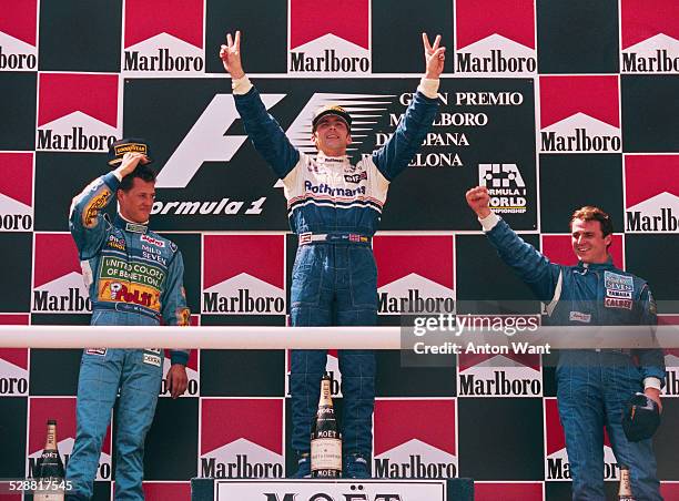 Damon Hill of Great Britain, driver of the Rothmans Williams Renault Williams FW16B Renault V10 celebrates on the podium with second placed Michael...