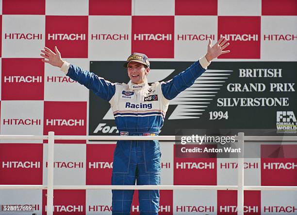 Damon Hill of Great Britain, driver of the Rothmans Williams Renault Williams FW16B Renault V10 celebrates winning the British Grand Prix on 10th...