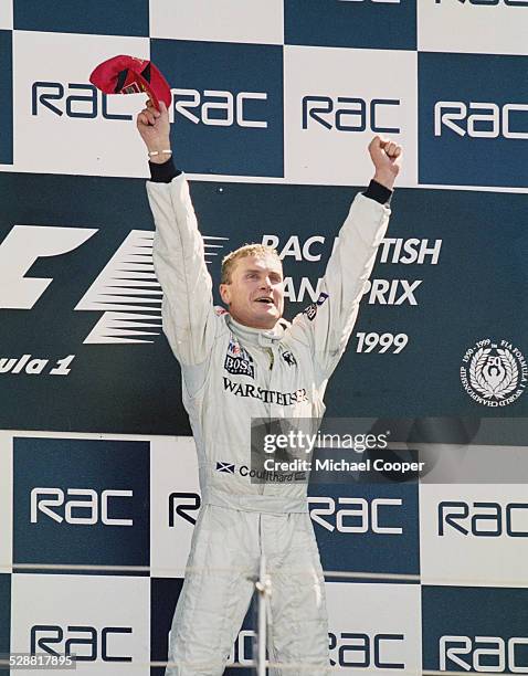 David Coulthard of Great Britain, driver of the West McLaren Mercedes McLaren MP4/14 Mercedes FO110H celebrates on the podium after winning the RAC...