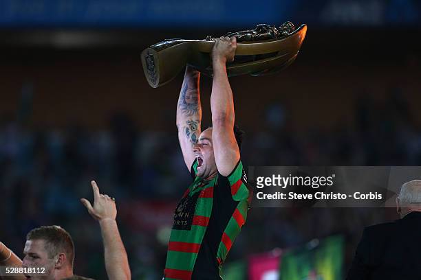 Rabbitohs John Sutton holds up the trophy after beating the Bulldogs 30 to 6 in the NRL Grand Final match at ANZ Stadium 2014. Sydney, Australia....