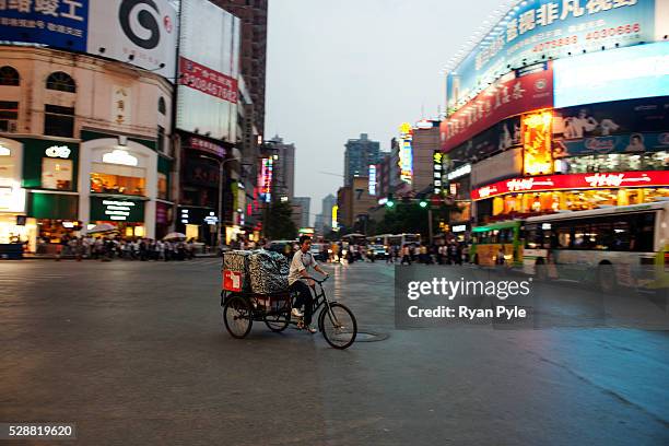 Man rides this three-wheel bicycle through a major shopping area in Changsha. Situated in the river valley along the lower part of Xiangjiang River,...