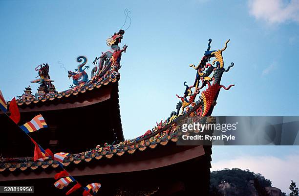 Dragons on the rooftop at the Nanputuo Temple in Xiamen. The Nanputuo Temple is located on the southeast of Xiamen Island. It is surrounded by the...