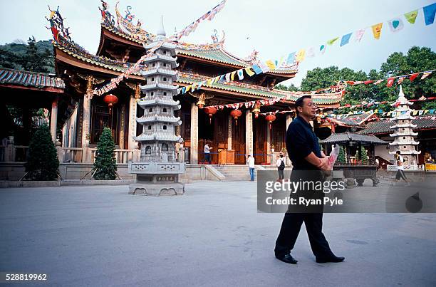 Visitor walks past the Heroic Treasure Hall at the Nanputuo Temple in Xiamen. The Nanputuo Temple is located on the southeast of Xiamen Island. It is...