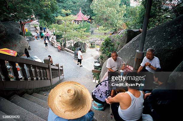 Visitors drink tea next to the stairs of the Nanputuo Temple in Xiamen. The Nanputuo Temple is located on the southeast of Xiamen Island. It is...