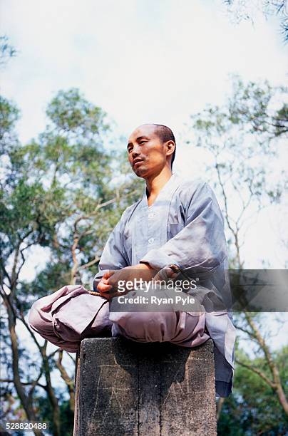 Monk meditates on the summit of the mountain behind the Nanputuo Temple in Xiamen. The Nanputuo Temple is located on the southeast of Xiamen Island....