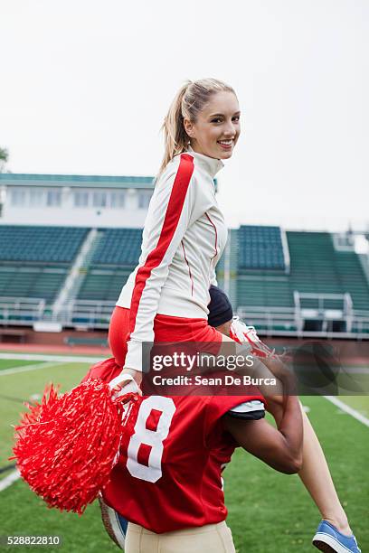 cheerleader with football player - joueur-de-football-américain photos et images de collection