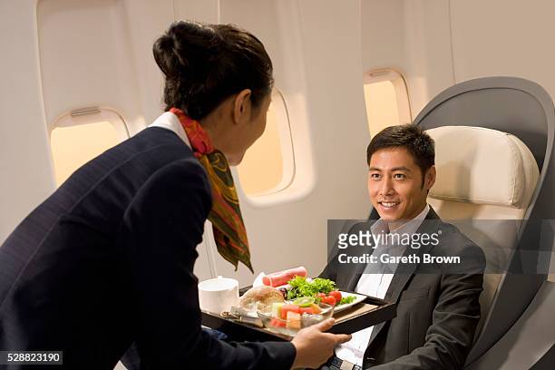 flight attendant serving dinner to man - airline food stock-fotos und bilder