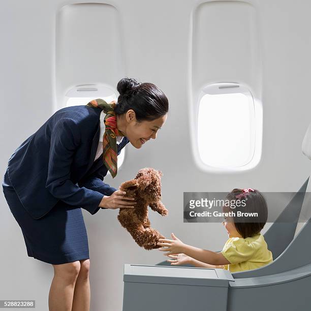 flight attendant giving teddy bear to girl - crew stock pictures, royalty-free photos & images