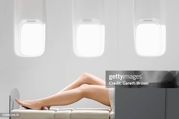 woman sleeping in reclining chair on airplane - jet lag stockfoto's en -beelden