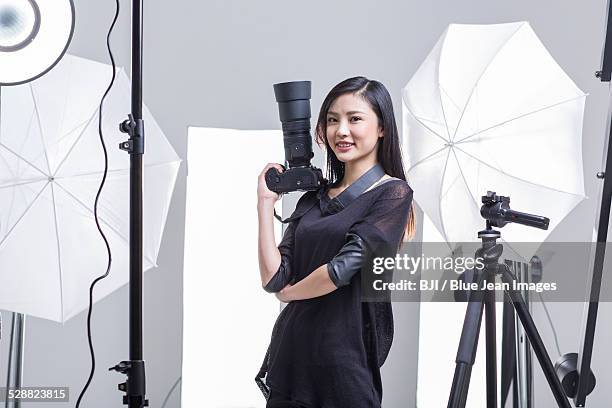 photographer standing in studio with camera - photoshoot bts stock pictures, royalty-free photos & images