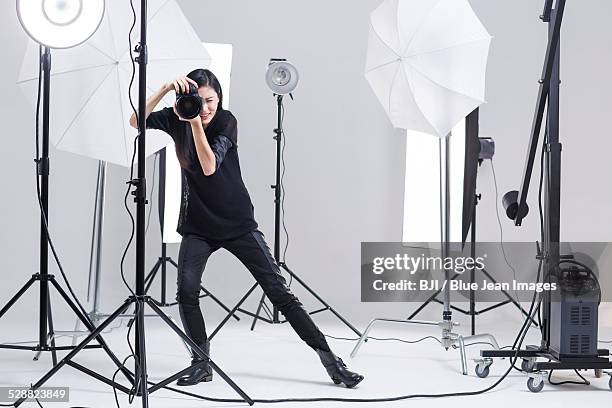 photographer taking picture in studio - professional photographer stock-fotos und bilder