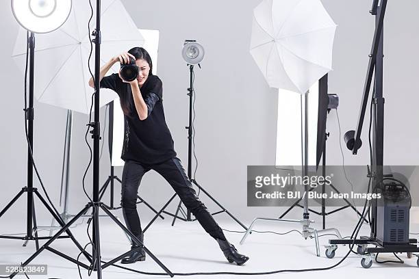 photographer taking picture in studio - servizio fotografico fotografías e imágenes de stock