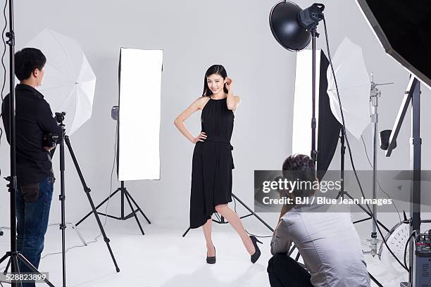 photographers taking pictures of female model in studio - glamorous female model photoshoot stock pictures, royalty-free photos & images