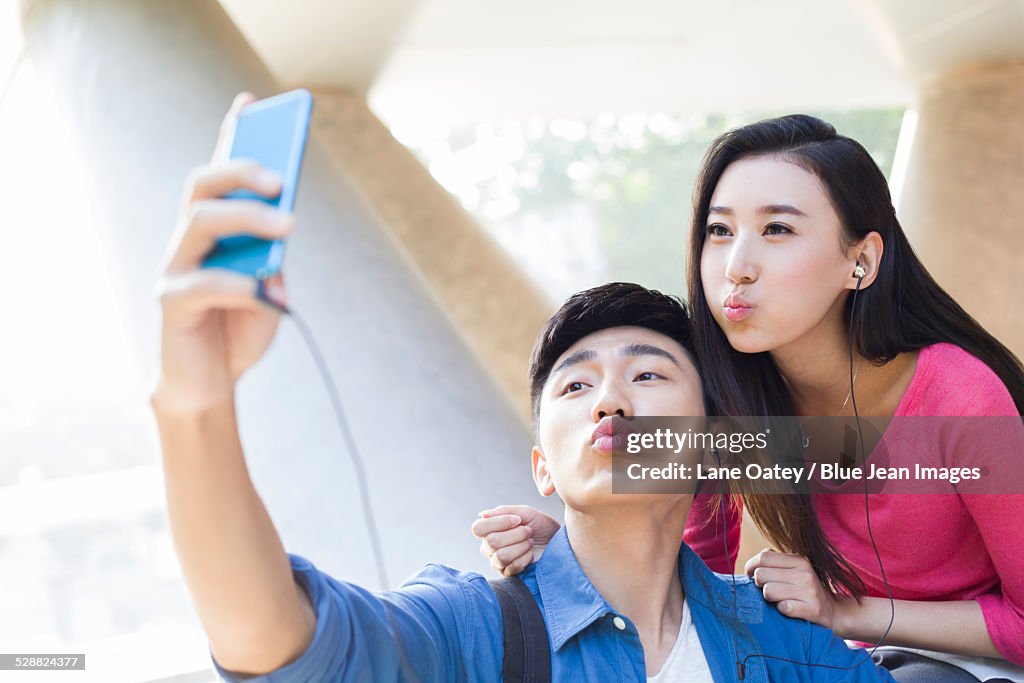 Young couple taking self portrait with a smart phone