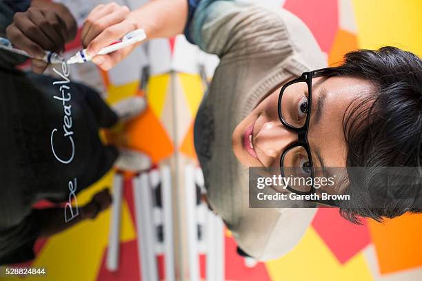 Male Designer Writing Be Creative On Glass Wall And Looking To Camera ...
