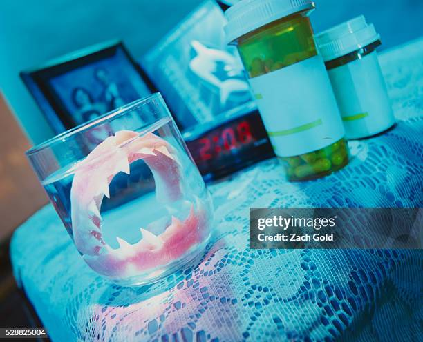sharklike dentures in glass of water - ominous clock stock pictures, royalty-free photos & images