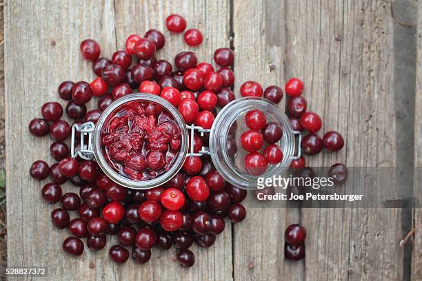 sour cherry chutney in a jar with fresh cherries around. - cerise sure photos et images de collection