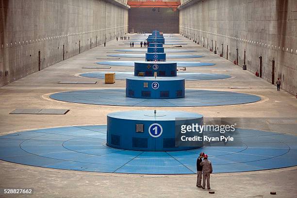 Workers walk inside a finished, and fully operational, turbine hall inside the Three Gorges Dam. The Three Gorges Dam Project, in Yicheng, Hubei,...