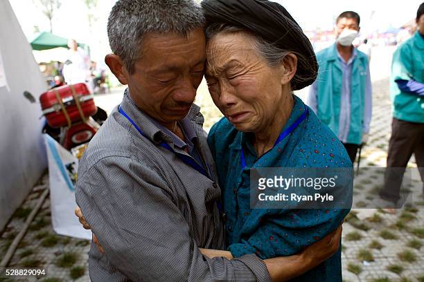 Son and mother console each other while remember what they have been through surviving the earthquake, in the Mianyang Football Stadium, home to over...