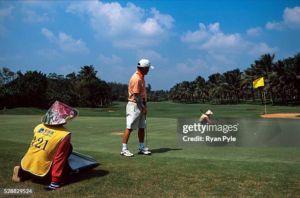 Golfer watches his putt at the Taida Golf Course just outside Haikou city, the capital of Hainan province in China. Taida Golf Course opened in the...