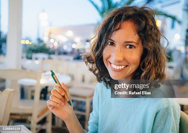 pretty happy woman holding pen - female authors stock pictures, royalty-free photos & images