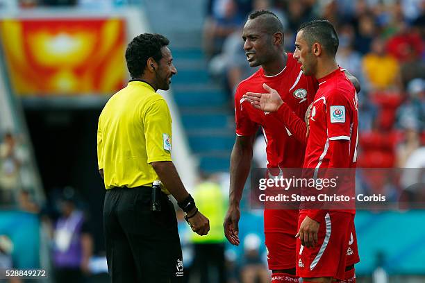 Palestine's Abdullah Jaber gets a yellow card from referee Abdulrahman Hussain go Qatar as he and teammates argue about the penalty decision at...