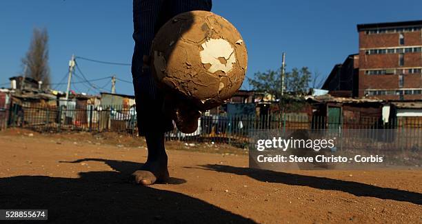 Locals play a morning game of soccer on a dirt pitch in Alexandra Township in Johannesburg, South Africa, during the 2010 World Cup.