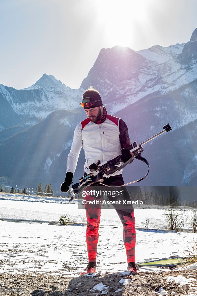 Biathlon athlete prepares to aim competition rifle