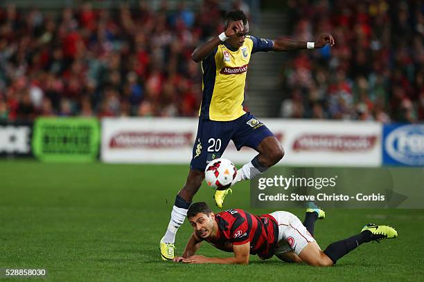 Mariners Bernie Ibini jumps over Wanderers Adam D'Apuzzo in this tackle at Parramatta Stadium. Sydney, Australia. Saturday 26th April 2014.