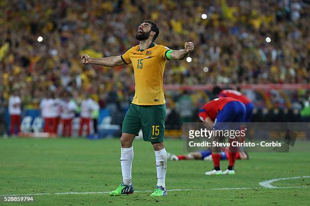 Australia's captain Mile Jedinak stands with both arms stretched after the referee blew his whistle to signal the end of the match and Australia...