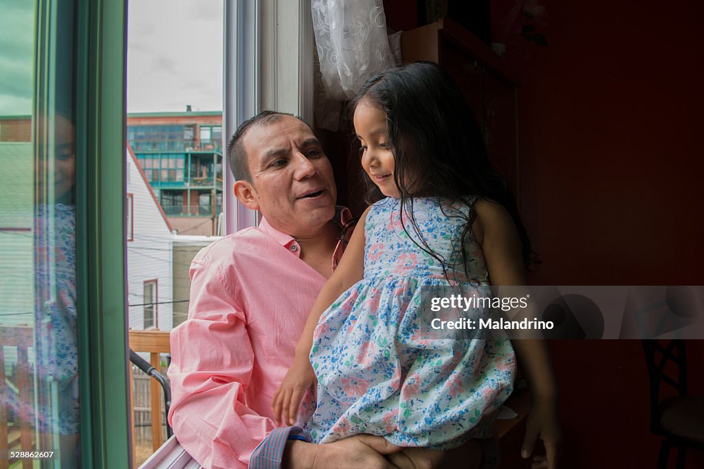 Father and daughter looking trough the window
