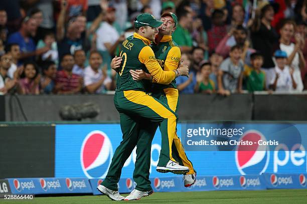 South Africa's David Smith celebrates with captain AB De Villiers after catching Dwayne Smith from the West Indies off the bowling of Imran Tahir at...