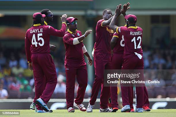 West Indies Jason Holder celebrates with teammates after taking the wicket of South Africa's opener Quinton De Kock at the Sydney Cricket Ground....