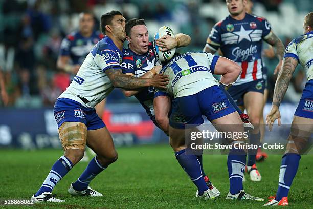 James Maloney of the Roosters is tackled by Bulldog's Joshua Jackson and Michael Lichaa during the round 21 NRL match between the Canterbury Bulldogs...