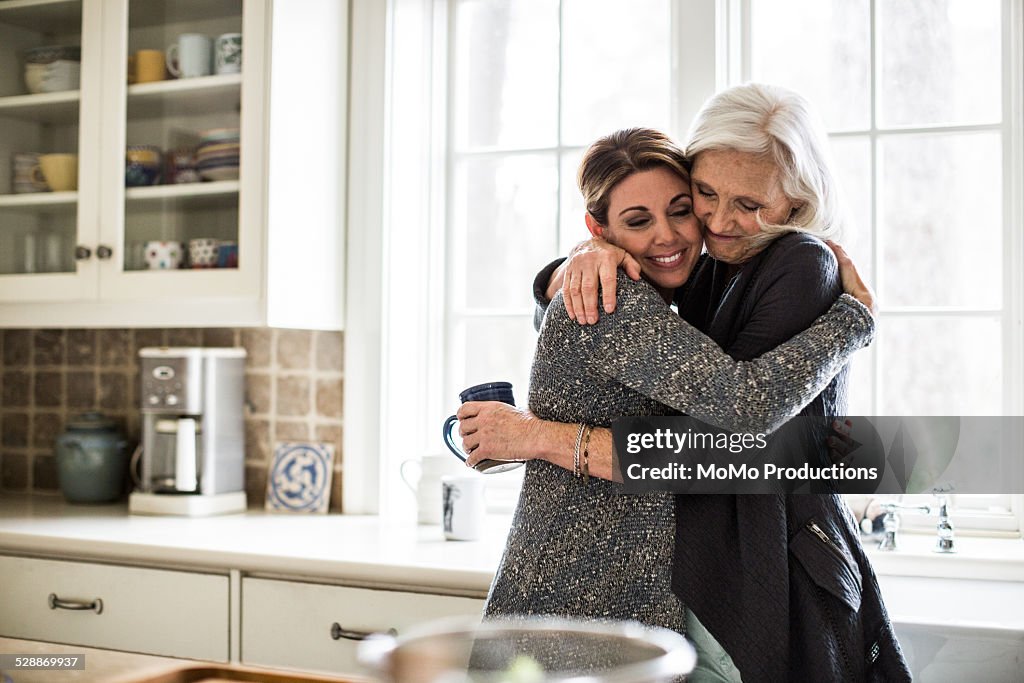 Mother and daughter hugging in kitchen