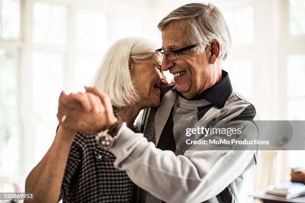 senior couple dancing in living room - romanticism stock pictures, royalty-free photos & images