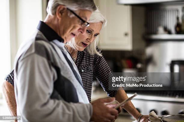 senior couple looking at tablet - financial freedom stock pictures, royalty-free photos & images