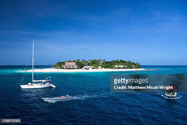 boats head towards beachcomber island, fiji. - beachcomber island stock pictures, royalty-free photos & images